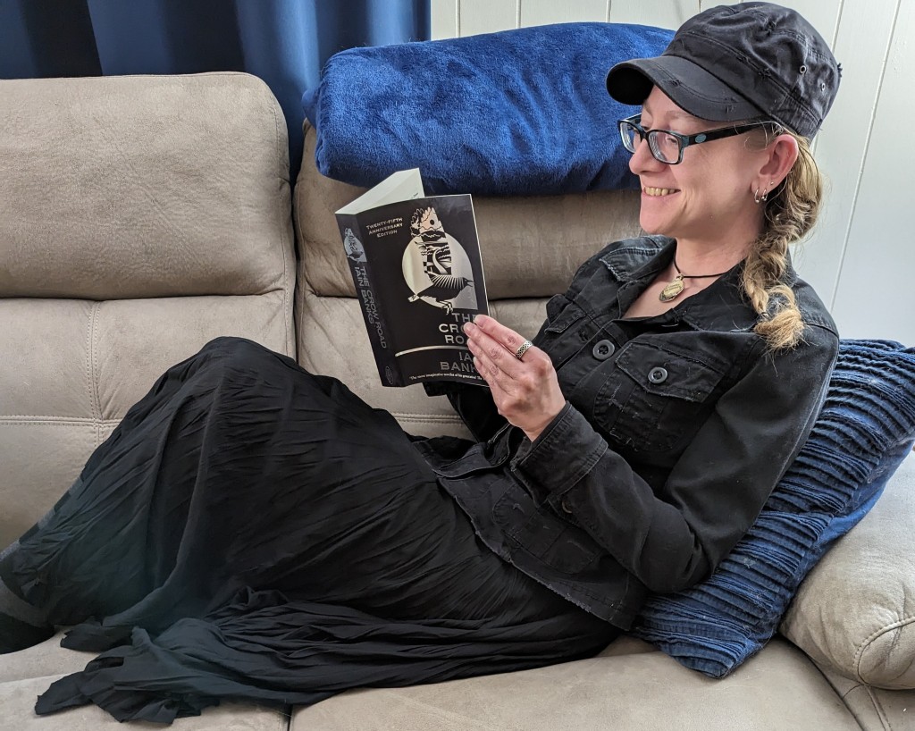 I'm sat on the couch reading "The Crow Road" and dressed in all black.